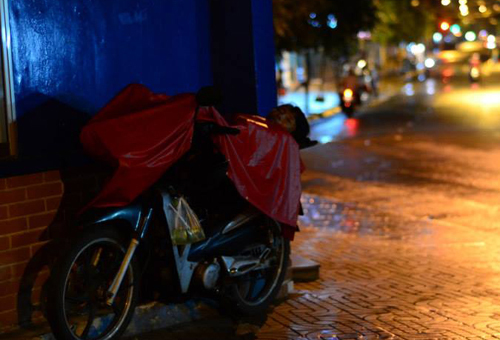 Cách đó không xa, anh xe ôm dùng chiếc áo mưa để làm chăn, tiếng ngáy ngủ lẫn trong tiếng mưa đêm.