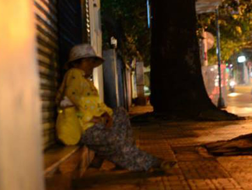 Cách Bệnh viện Ung bướu chừng 300m, hướng về ngã 3 Phan Đăng Lưu - Nơ Trang Long, người phụ nữ chọn mái hiên của một cửa hàng làm nơi để "ngồi" ngủ. 