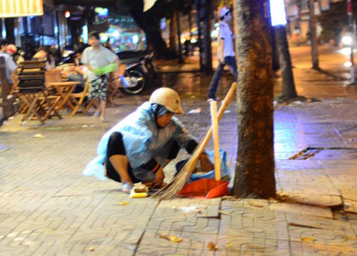 Khuya muộn, trong khi nhiều người đã yên giấc, bà lão vẫn đội mưa lục túi rác tại một quán nhậu trên đường Trần Hưng Đạo, quận 5, để nhặt ve chai. 