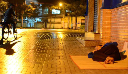 12h khuya, trước cổng Bệnh viện An Bình, người phụ nữ vẫn ngủ say giấc trong mưa sau một ngày bán vé số mệt mỏi. Không có chăn, đôi dép vốn thường dùng làm gối của bà vừa bị mất.
