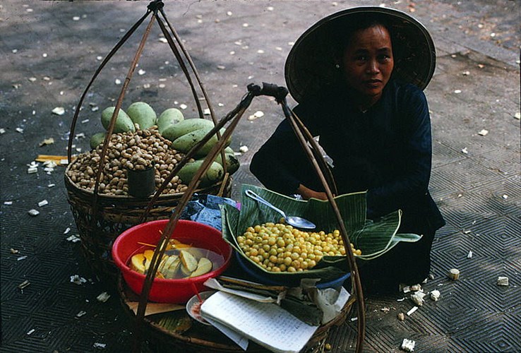 Một gánh quà vặt vỉa hè với các món xoài dầm, đậu phộng, chùm ruột..., Sài Gòn năm 1968.
