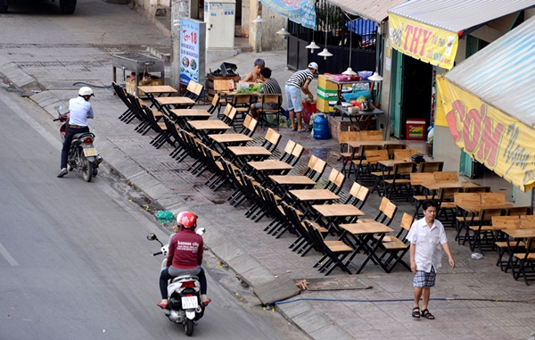 Đầu giờ chiều các quán nhậu trên đường Phạm Văn Đồng bắt đầu bày bàn ghế ra tận sát bờ đường để chuẩn bị bán cho khách vào buổi tối - Ảnh: Duyên Phan.