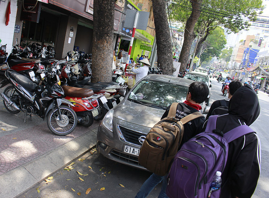 Buôn bán tấp nập, bãi giữ xe đông đúc trên vỉa hè và ô tô, taxi chờ khách xếp hàng dài trên đường Nguyễn Thị Minh Khai (quận 1) "đẩy" người đi bộ ra lòng đường nguy hiểm.