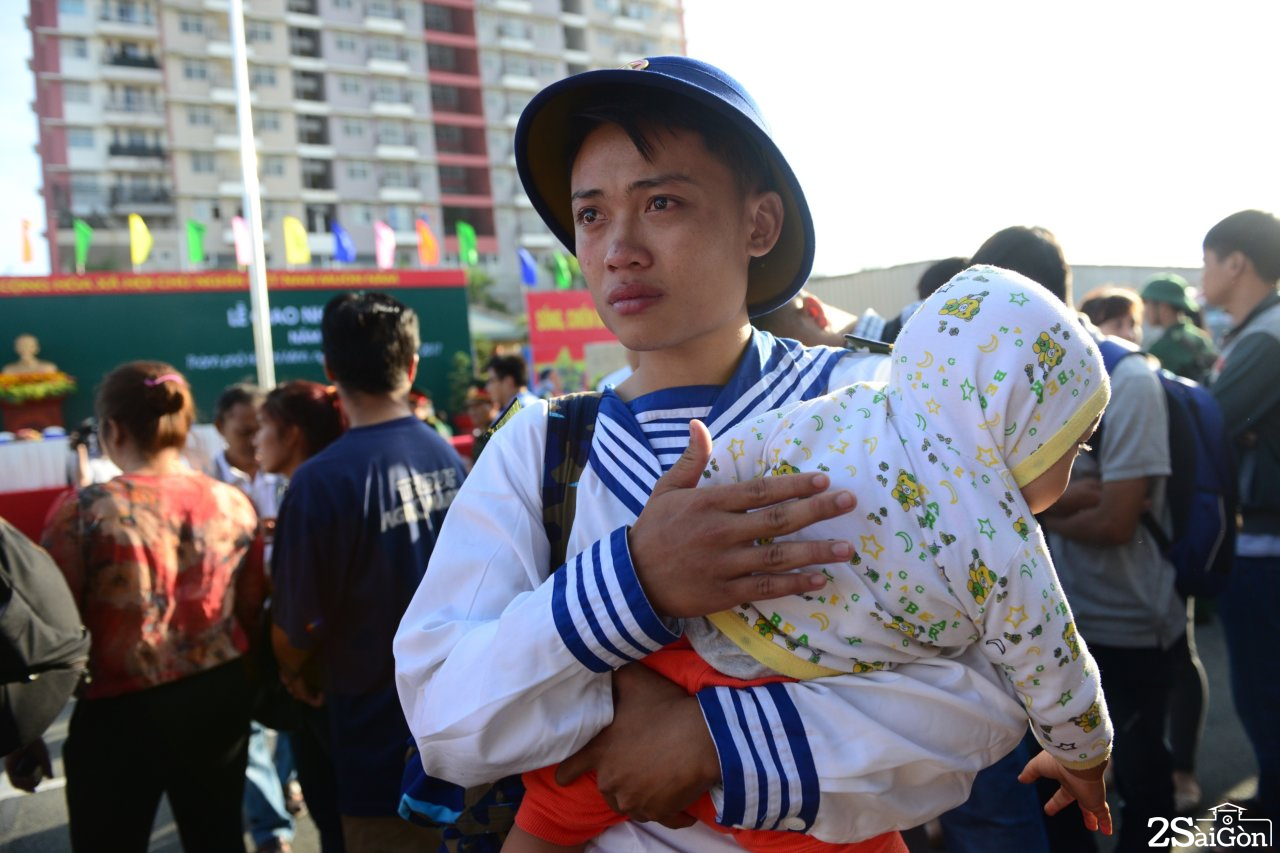 Tân binh Nguyễn Tấn Phong ôm con trai mới 1 tuổi nghẹn ngào trong lễ giao nhận quân tại quận 9 sáng 16-2 - Ảnh: DUYÊN PHAN 