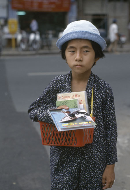 Em bé bán sách báo dạo trên đường phố. Catherine rất xúc động khi nhìn nét mặt, vóc dáng của cô bé đều toát lên sự vất vả. 