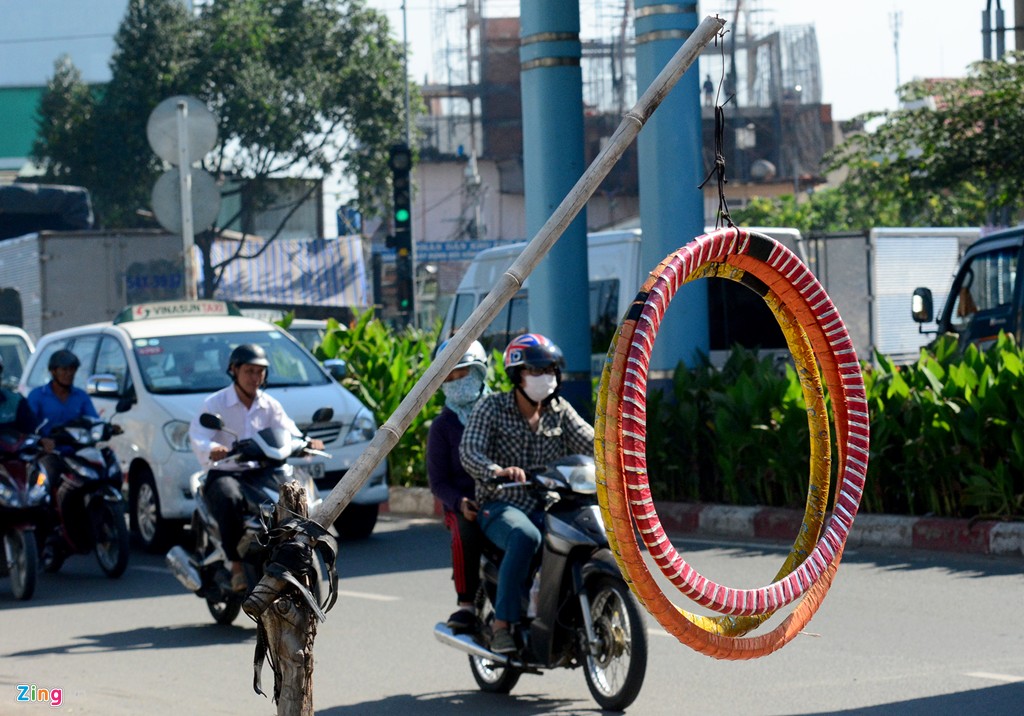  Lốp được treo lên gậy trên đường Tây Thạnh, quận Tân Phú. Ông chủ đang tránh nắng trong góc khuất. Dù chưa nhìn thấy thợ sửa nhưng người qua đường nhìn thấy là biết có hàng sửa xe máy, xe đạp.
