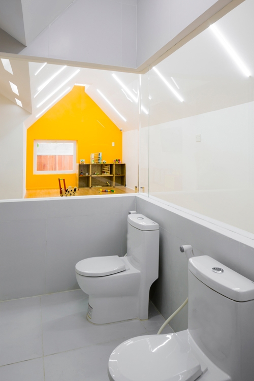Khu vệ sinh nằm trong phòng học của trẻ với mảng kính phía trên vừa đủ đảm bảo riêng tư cho các em nhỏ, vừa nhận được ánh sáng bên ngoài.