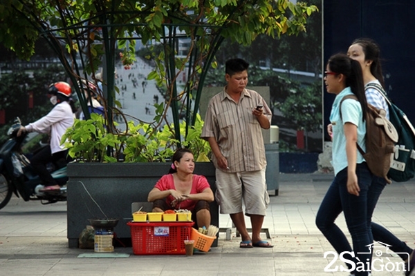 Nhiều người chiếm ghế ngồi ở Phố Đi Bộ làm nơi buôn bán đồ ăn vặt, tấp nập mua bán. Ảnh: Người Lao Động.