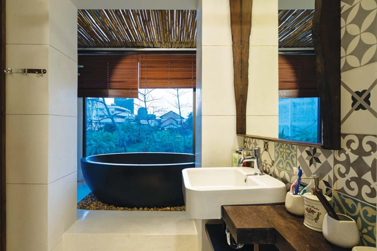 Phòng tắm hiện đại mà gần gũi với bồn tắm đá và gạch bông ốp tường.